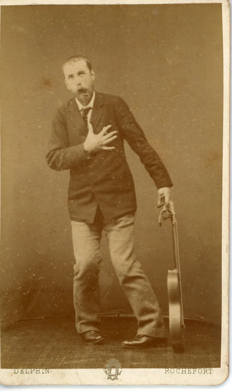 Photo d'archive en sépia un homme singeant un arrêt cardiaque avec une guitare